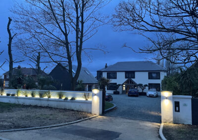 Evening light. Gateway, triple garage and driveway and completed front elevation