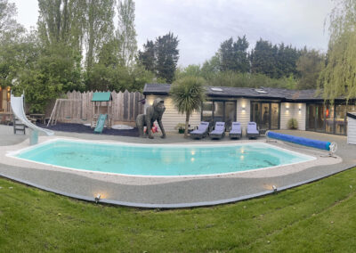 Outdoor swimming pool with slide and resin bound surround